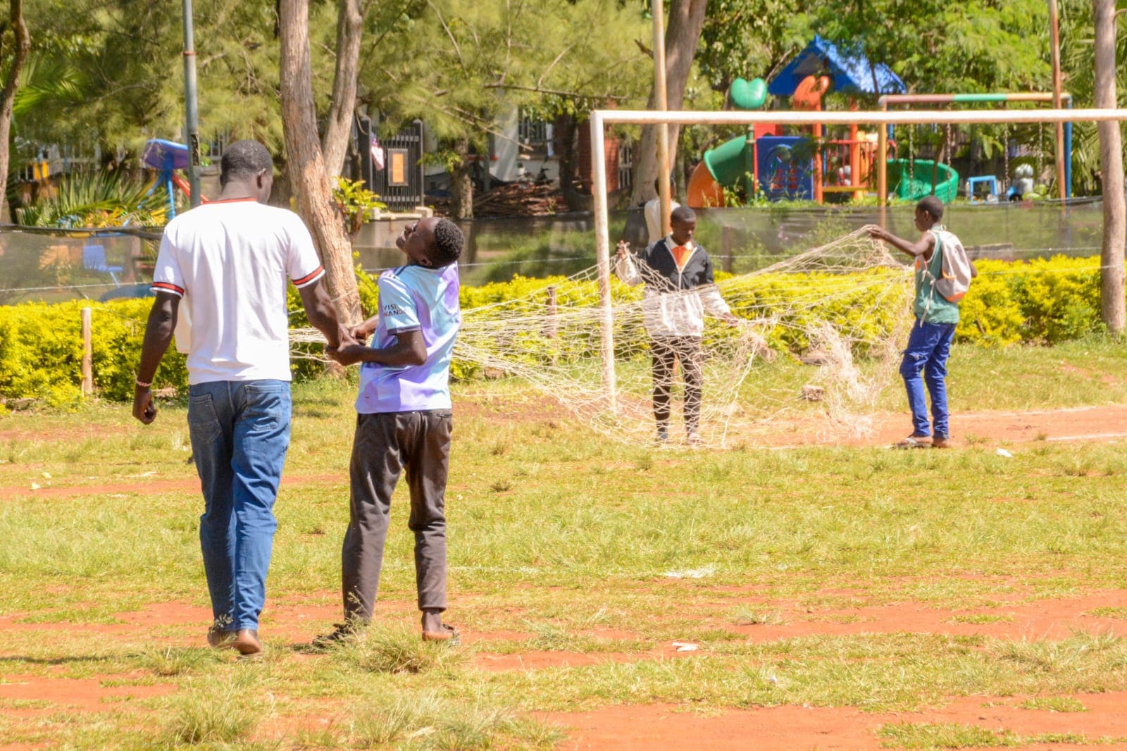 Boys setting up a football net together